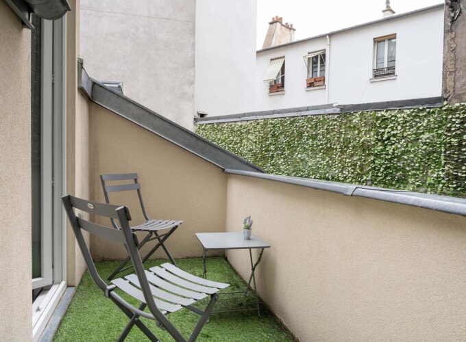 Chambre Triple Terrasse avec petit balcon comprenant deux chaises et une table à l’Hôtel George