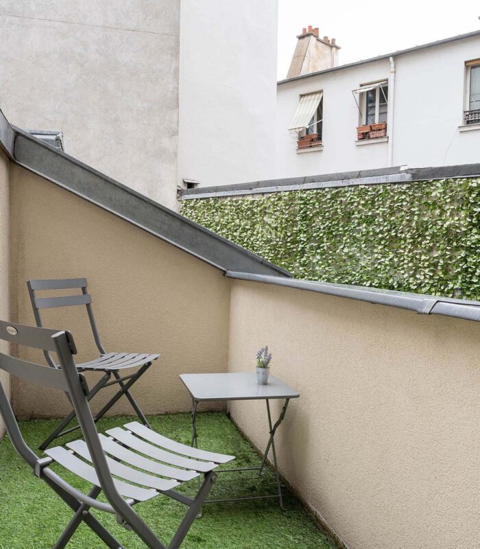 Chambre Triple Terrasse avec petit balcon comprenant deux chaises et une table à l’Hôtel George