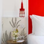 Chambre Twin avec une table de chevet et un vase de fleurs dessus à l’Hôtel George