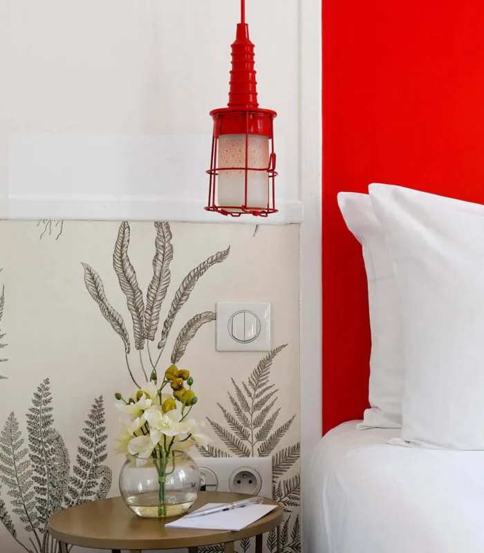 Chambre Twin avec une table de chevet et un vase de fleurs dessus à l’Hôtel George