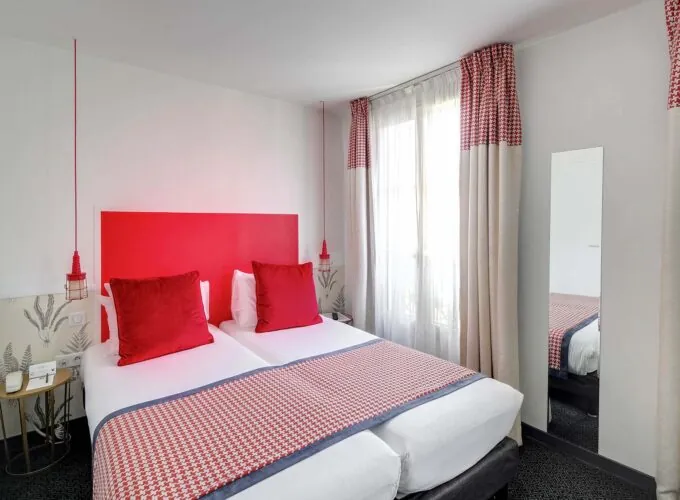 Chambre Twin avec deux lits et une tête de lit rouge à l’Hôtel George