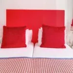 Chambre Twin avec deux lits et une tête de lit rouge à l’Hôtel George