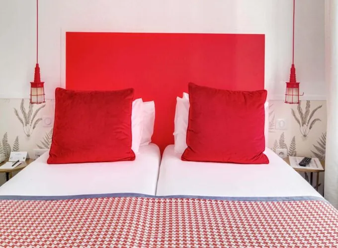 Chambre Twin avec deux lits et une tête de lit rouge à l’Hôtel George
