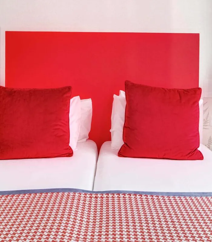 Chambre Twin avec deux lits et une tête de lit rouge à l’Hôtel George
