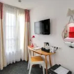 Chambre Twin avec un bureau et une télévision à écran plat à l’Hôtel George