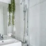 Salle de bain de la Chambre Twin avec un lavabo, une douche et un miroir à l’Hôtel George