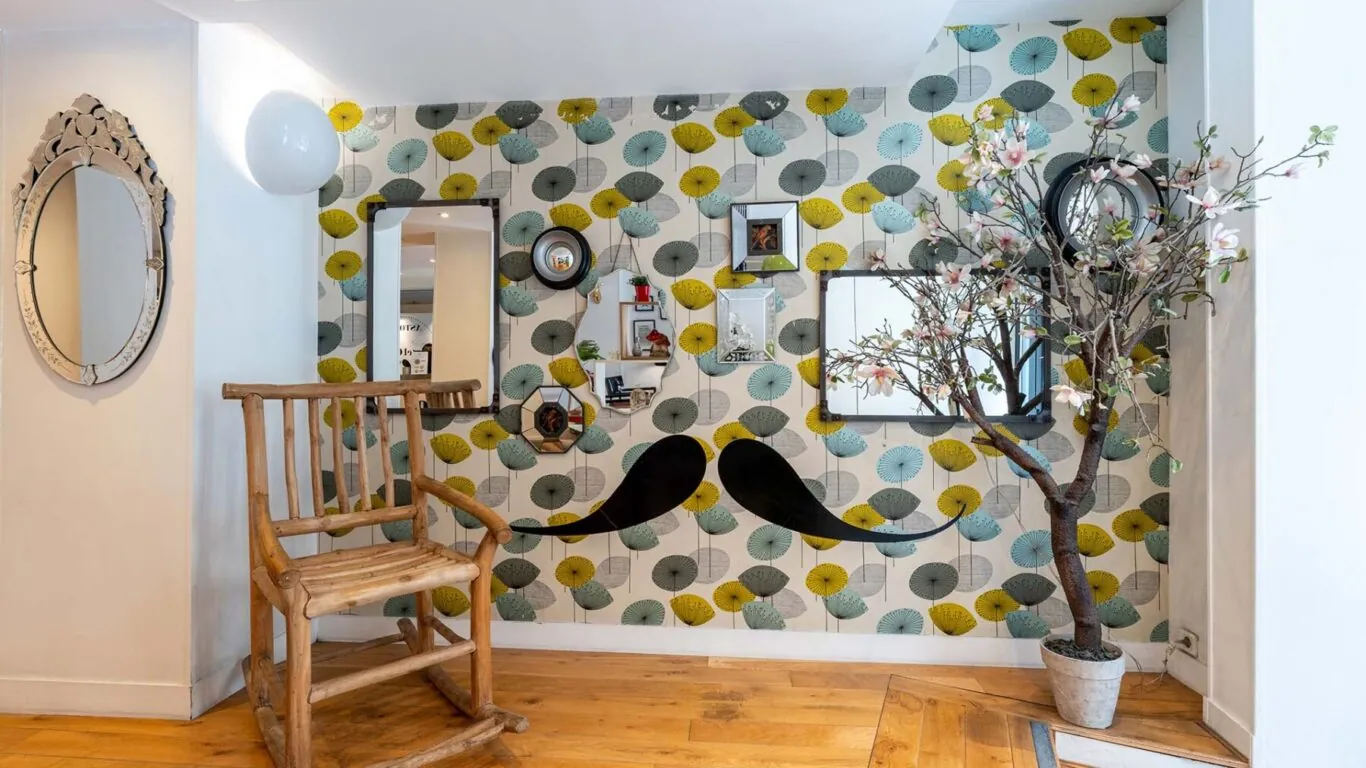 Vue du lobby de l’Hôtel George 3 étoiles à Paris, mettant en valeur une harmonie de couleurs élégantes et sa décoration pop et ludique, créant une atmosphère raffinée et accueillante