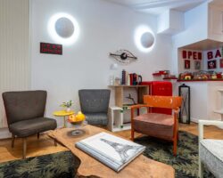 Lobby de l’hôtel George 3 étoiles à Paris aux couleurs élégantes, à la décoration pop et ludique, et à l’atmosphère raffinée et accueillante.