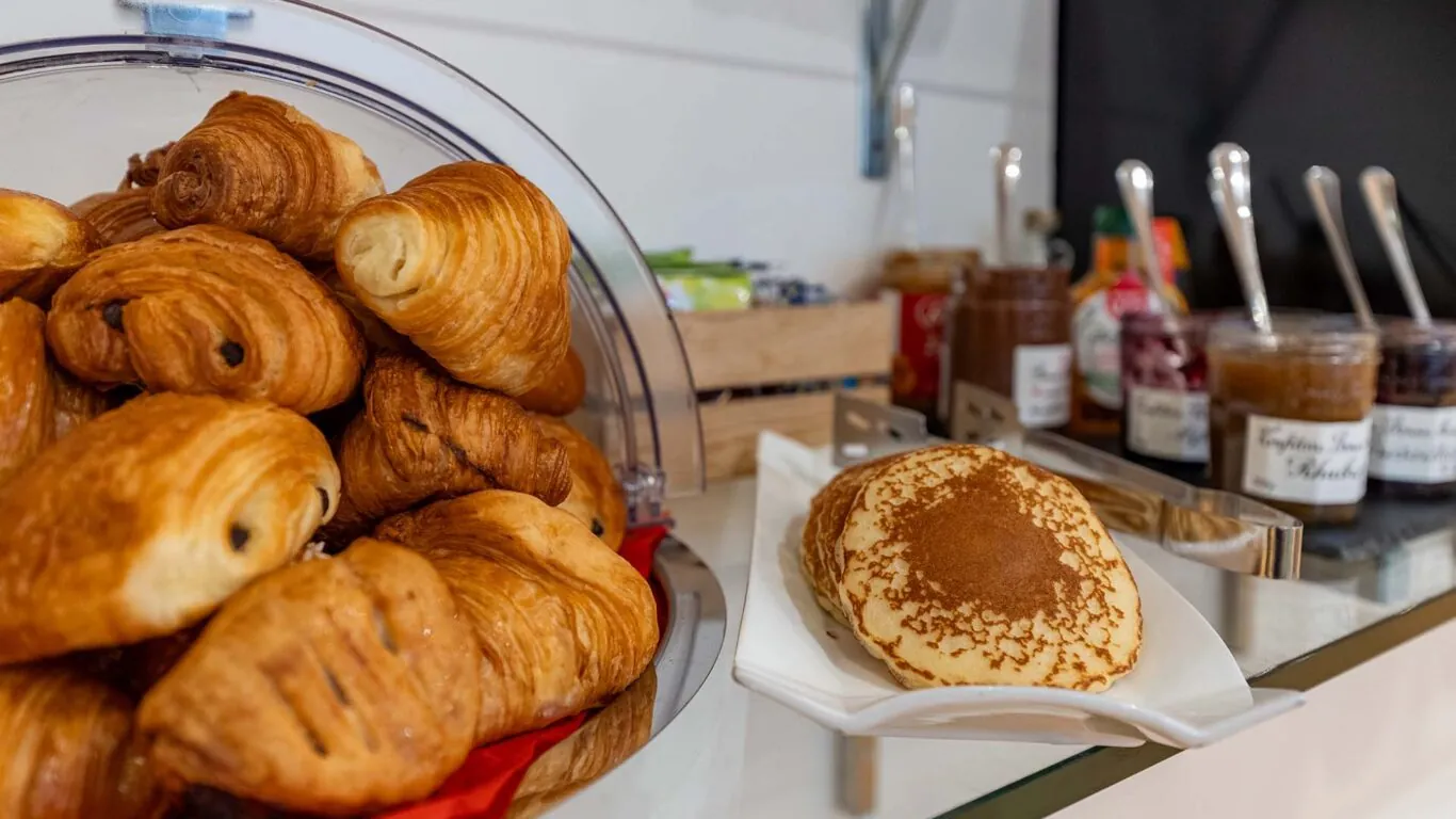 Buffet petit-déjeuner à l’hôtel George à Paris avec viennoiseries, pains frais, fromages, charcuterie, yaourts, fruits et céréales