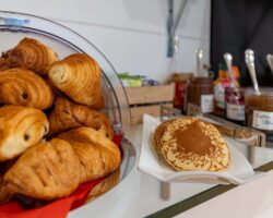 Buffet petit-déjeuner à l’hôtel George à Paris avec viennoiseries, pains frais, fromages, charcuterie, yaourts, fruits et céréales