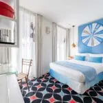 Chambre Communicante à l’hôtel Joke avec un lit et une roue sur le mur