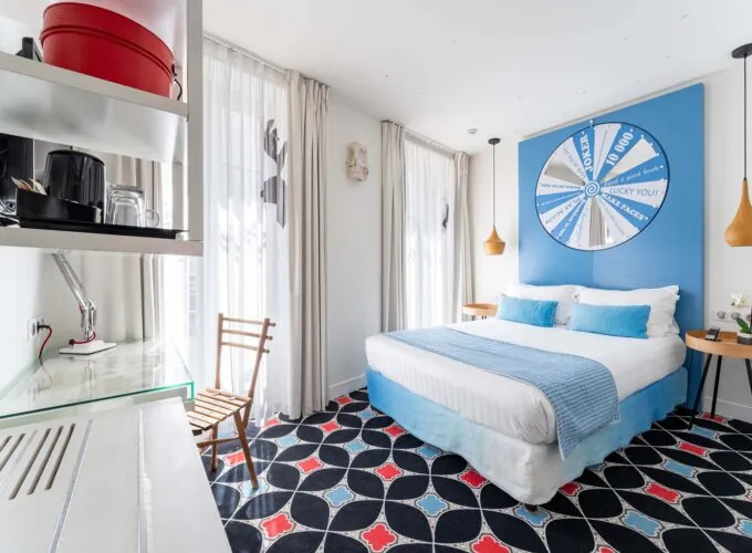 Chambre Communicante à l’hôtel Joke avec un lit et une roue sur le mur