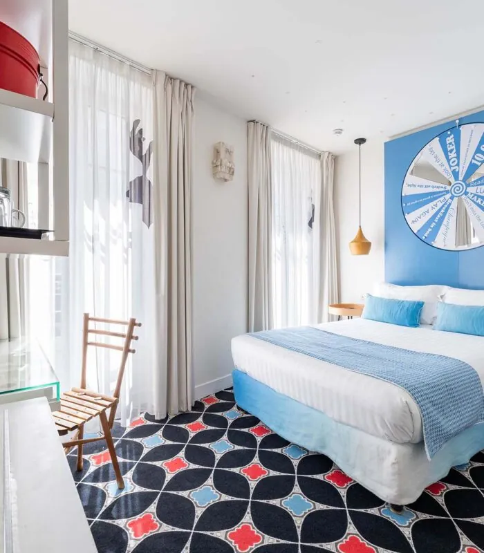 Chambre Communicante à l’hôtel Joke avec un lit et une roue sur le mur