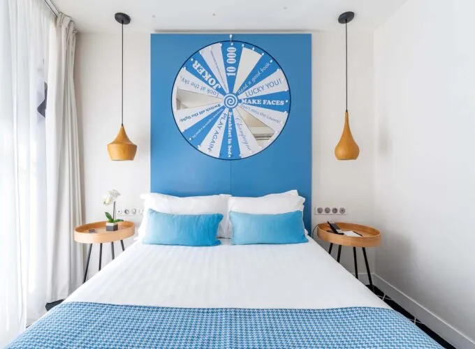 Chambre Communicante à l’hôtel Joke avec un lit et une roue sur le mur