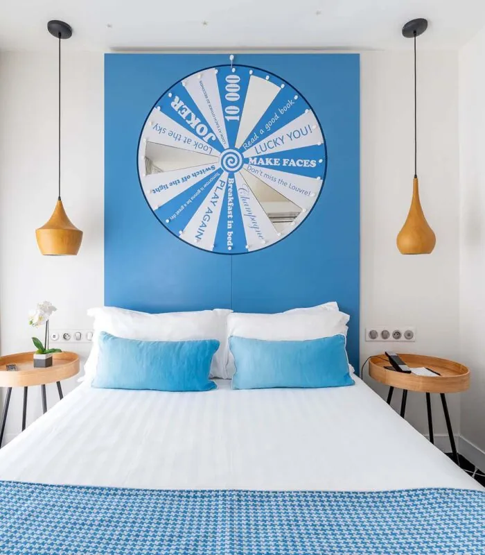 Chambre Communicante à l’hôtel Joke avec un lit et une roue sur le mur