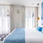 Chambre Communicante à l’hôtel Joke avec un lit et une roue sur le mur