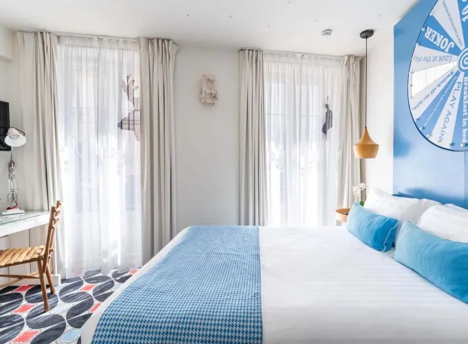 Chambre Communicante à l’hôtel Joke avec un lit et une roue sur le mur