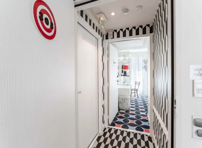 Couloir de la Chambre Communicante à l’hôtel Joke avec une enseigne sur le mur