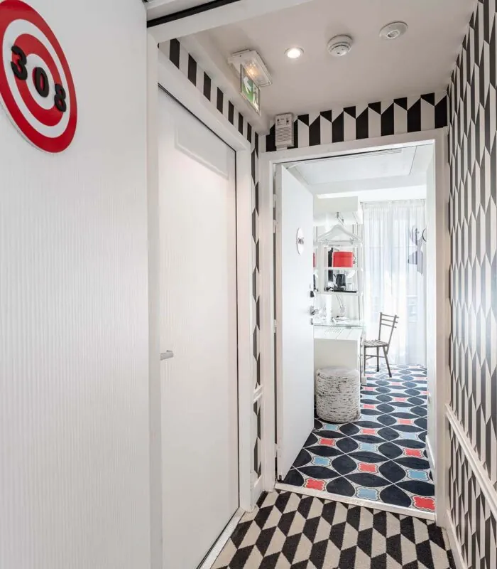 Couloir de la Chambre Communicante à l’hôtel Joke avec une enseigne sur le mur