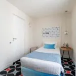 Chambre Communicante à l’hôtel Joke avec un lit simple et une enseigne sur le mur