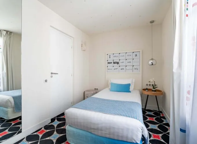 Chambre Communicante à l’hôtel Joke avec un lit simple et une enseigne sur le mur