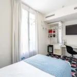 Chambre Communicante à l’hôtel Joke avec un lit,un bureau et une télévision à écran plat