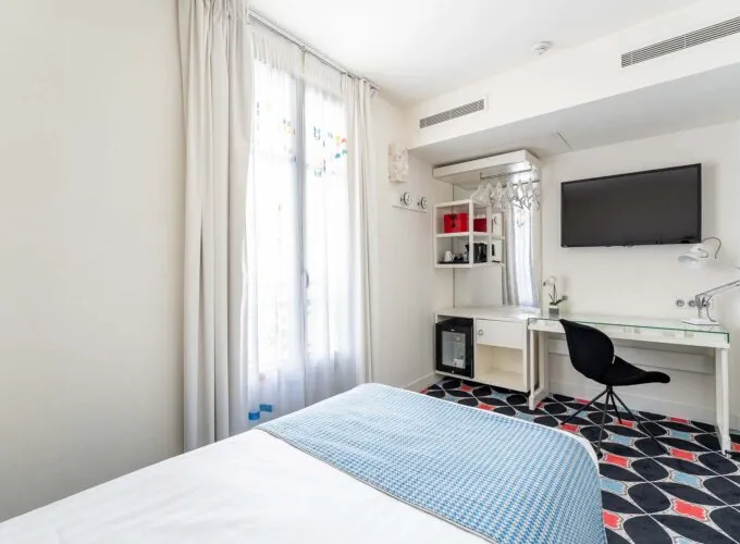 Chambre Communicante à l’hôtel Joke avec un lit,un bureau et une télévision à écran plat