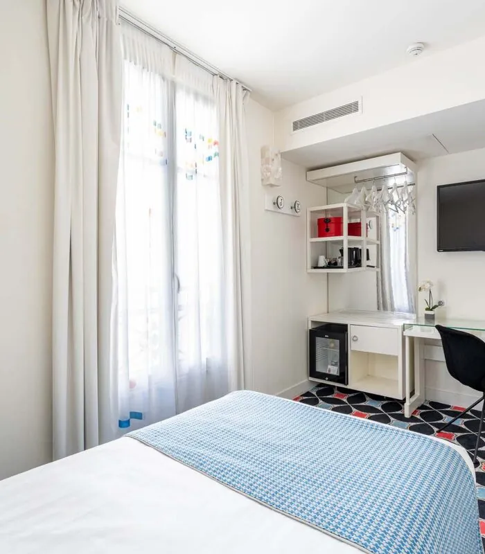 Chambre Communicante à l’hôtel Joke avec un lit,un bureau et une télévision à écran plat