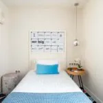 Chambre Communicante à l’hôtel Joke avec un lit simple et une enseigne sur le mur