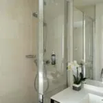 Salle de bain de la Chambre Communicante à l’hôtel Joke avec un lavabo,une douche et un miroir