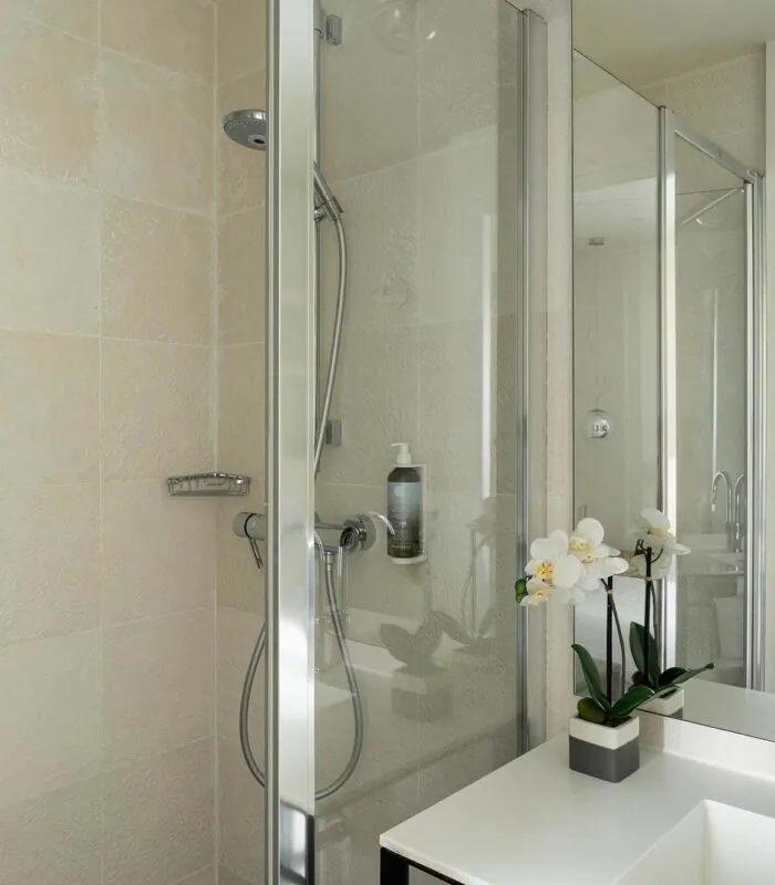 Salle de bain de la Chambre Communicante à l’hôtel Joke avec un lavabo,une douche et un miroir