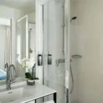 Salle de bain de la Chambre Communicante à l’hôtel Joke avec un lavabo,une douche et un miroir