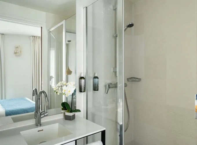 Salle de bain de la Chambre Communicante à l’hôtel Joke avec un lavabo,une douche et un miroir