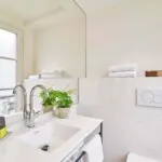 Salle de bain de la Chambre Double à l’hôtel Joke avec un lavabo et un miroir avec un bouton