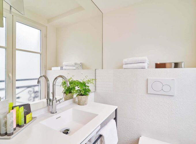 Salle de bain de la Chambre Double à l’hôtel Joke avec un lavabo et un miroir avec un bouton