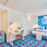 Chambre Double Supérieure à l’hôtel Joke avec un lit et un bureau et une roue sur le mur