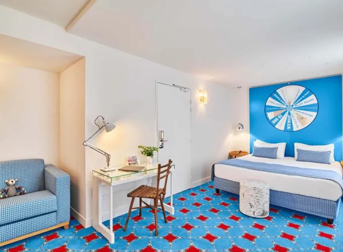 Chambre Double Supérieure à l’hôtel Joke avec un lit et un bureau et une roue sur le mur