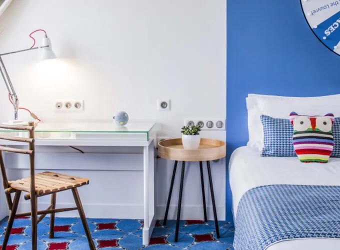 Chambre Privilège à l’hôtel Joke avec un mur à rayures bleues et blanches et un coussin avec une chouette