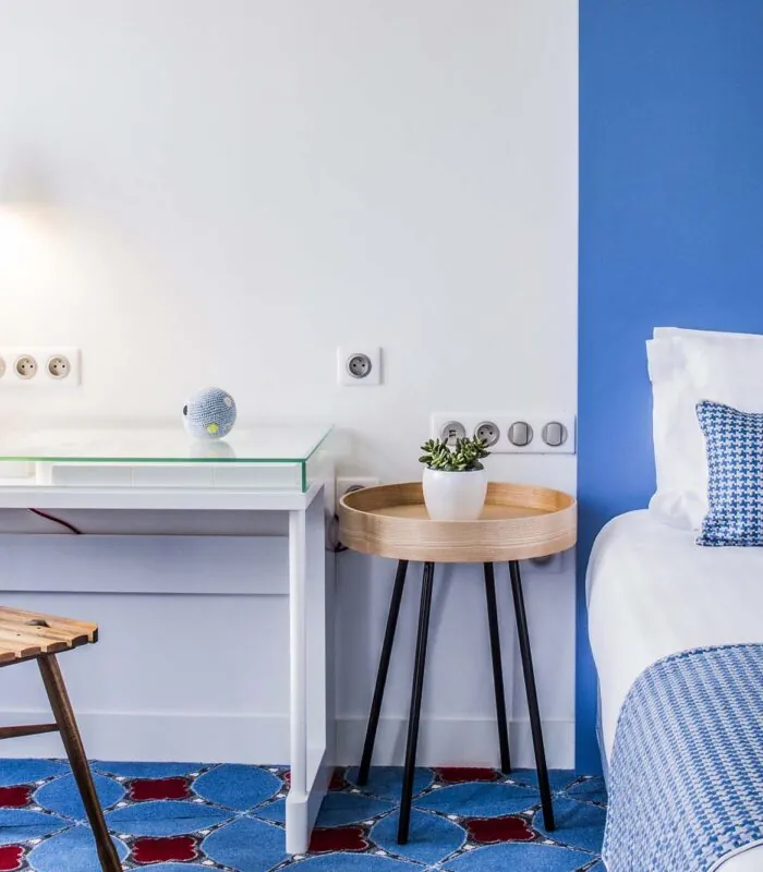 Chambre Privilège à l’hôtel Joke avec un mur à rayures bleues et blanches et un coussin avec une chouette