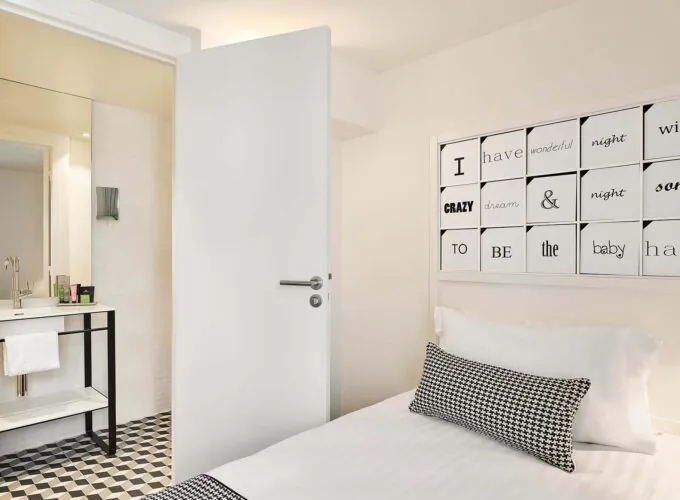 Chambre Single à l’hôtel Joke avec un lit et une enseigne