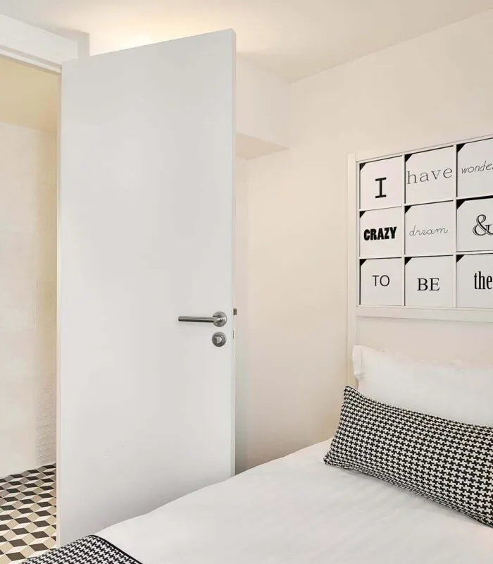 Chambre Single à l’hôtel Joke avec un lit et une enseigne