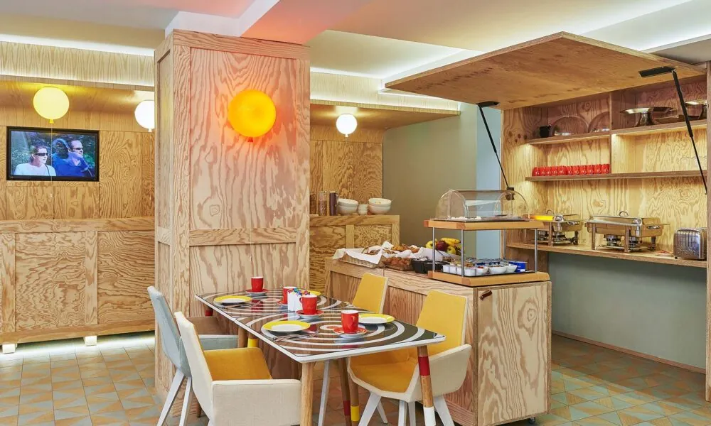 Salle de petit-déjeuner de l’hôtel Joke à Paris avec un buffet varié,une atmosphère chaleureuse et animée