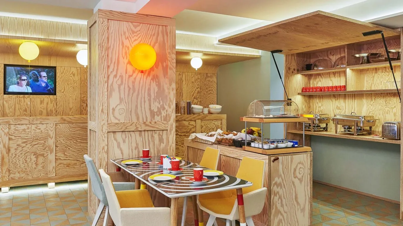 Salle de petit-déjeuner de l’hôtel Joke à Paris avec un buffet varié,une atmosphère chaleureuse et animée