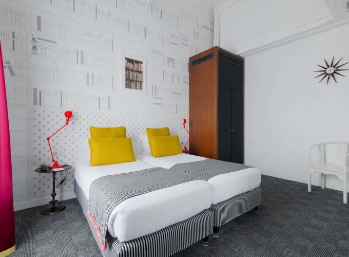 Appartement chambre à l’hôtel Joyce avec deux lits et une horloge sur le mur