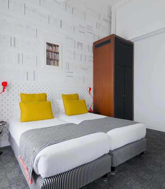 Appartement chambre à l’hôtel Joyce avec deux lits et une horloge sur le mur