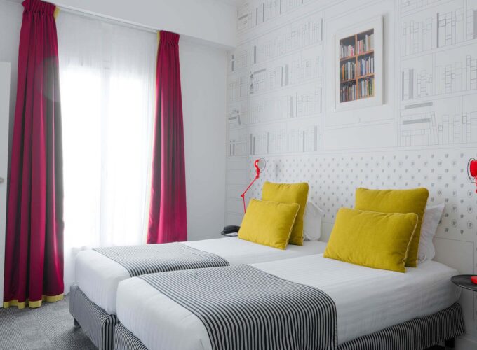 Appartement chambre à l’hôtel Joyce avec deux lits et un papier peint bibliothèque