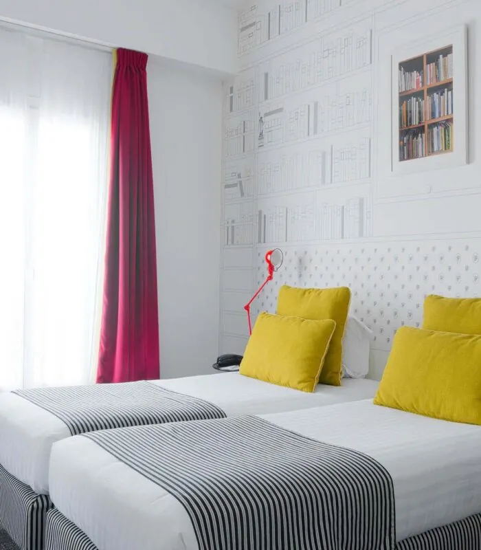 Appartement chambre à l’hôtel Joyce avec deux lits et un papier peint bibliothèque
