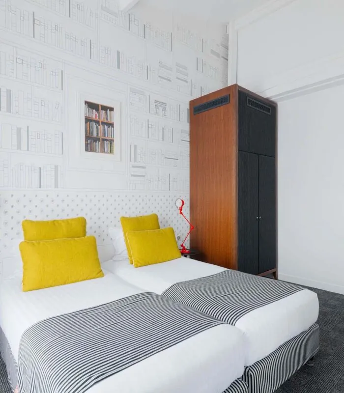 Appartement chambre à l’hôtel Joyce avec deux lits et une horloge sur le mur