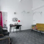 Appartement salon à l’hôtel Joyce avec un canapé jaune et un bureau
