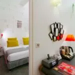 Appartement à l’hôtel Joyce avec un lit et un bureau sur lequel se trouve un magazine Paris